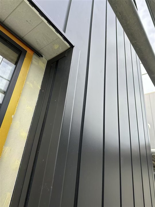 Vertical aluminium exterior cladding beside a window