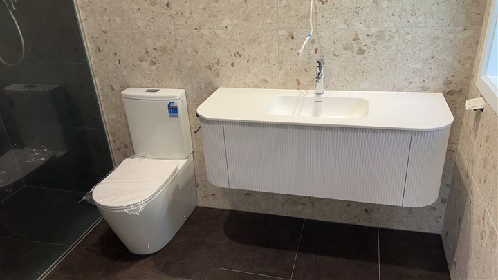 Bathroom vanity and toilet with patterned wall finish